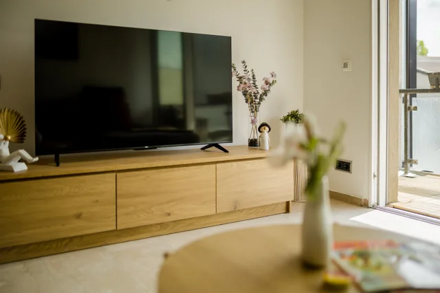 Fernseher auf einem Holzsideboard im Wohnbereich.